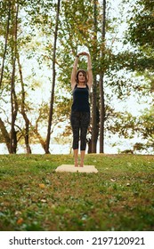 A Yogi Woman Practices Yoga In The Forest In Autumn. She Is In A Crescent Moon Yoga Pose.