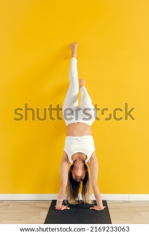 Similar – Woman doing a handstand on the beach