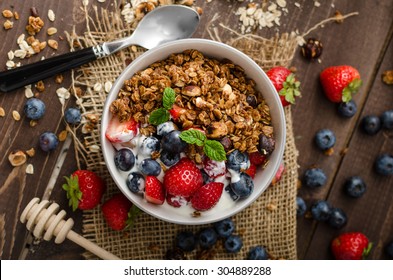 Yogurt with baked granola and berries in small bowl, strawberries, blueberries. Granola baked with nuts and honey for little sweetness. Homemade yogurt - Powered by Shutterstock