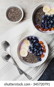 Yogurt with berries, banana, almonds and Chia seeds, bowl of healthy Breakfast every morning, vintage style, superfood and detox concept, top view - Shutterstock ID 345720791