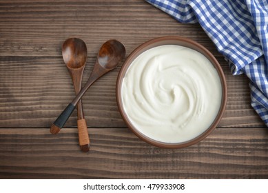 Yogurt In Bowl With Spoon On Wooden Background, Top View