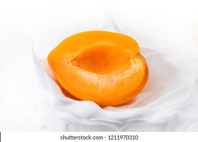 Yogurt with Fresh delicious apricot. Half of juicy apricot in yogurt, milk or cheese mass, close up