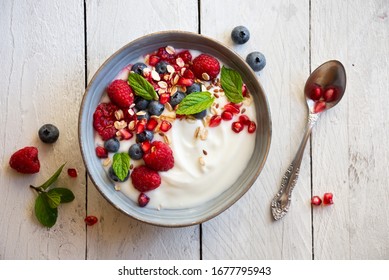 Yogurt with fresh fruit and berries (raspberry, pomegranate, blueberry) and mint for healthy breakfast - Powered by Shutterstock