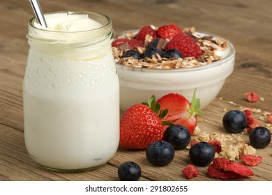 yogurt with fruit and mÃ¼sli on wooden background