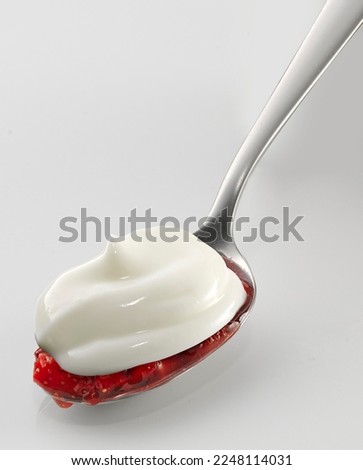 Yogurt on spoon,  strawberry, isolated on white background