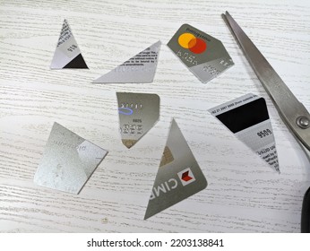 Yogya - ID, Sept 16th, 2022. Cut Up Credit Cards On The White Wooden Table With A Scissors. Credit Card Pieces.