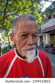 Yogya, Indonesia, September 8, 2022 : Old Man In Red Shirt Smiling Friendly