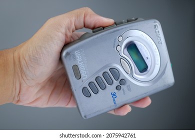 Yogyakarta, 17 November 2021. Hand Holding Old Cassette Player Sony Walkman Isolated On Grey Background.