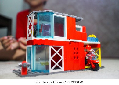 Yogyakarta 19 Oct 2019 - A Kids Is Sitting Behind His Lego Block Toys With A Factory Red Theme During School Day Off