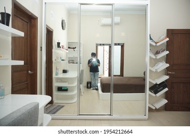Yogyakarta, Indonesia - April 12 2021: Minimalist modern bedroom with mirror wardrobe and shoe rack from several angle.
