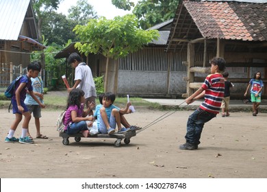 Yogyakarta, Indonesia - December 3, 2018: Children Playing In The Field, A Child Pulling Wooden Wagon That Many Children Ride