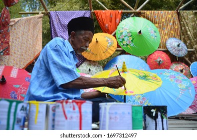 Yogyakarta, Indonesia - March 2018 : An Old Grandfather Was Working On Making A Painting Umbrella