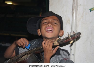 Yogyakarta, Indonesia - March 28th 2017 : A Busker Boy Singing On Malioboro Street In Yogyakarta At Night