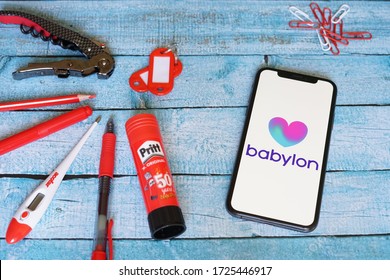 Yogyakarta, Indonesia - May 08, 2020; Babylon Iphone Screen On A Blue Table With Red Stationery. Babylon Health Is A Health Service Provider. #Babylon Health