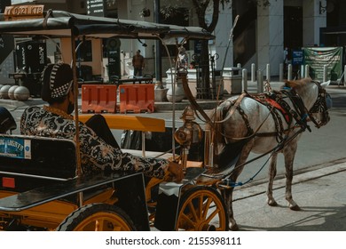 Yogyakarta, Indonesia, Mei, 2022 - The coachman of the wagon is resting on the side of the road in Yogyakarta