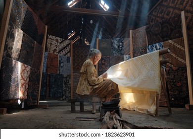 Yogyakarta / Indonesia - September 17, 2020: The process of making hand-written batik on a cloth with heated candles typical of Imogiri Jogja in a traditional house with low light