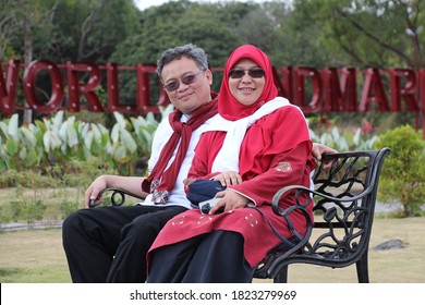 Yogyakarta, Indonesia, September 28, 2020. The Couple In Red Suits Were Sitting In The Lawn Chairs