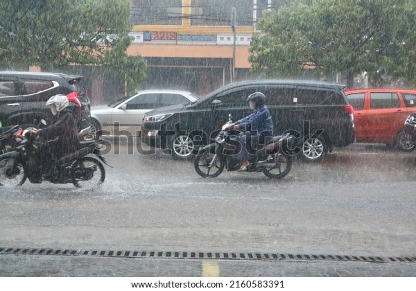 yogyakarta, indonesia-may, 26, 2022: the\
situation of a busy road during heavy rains was photographed with a\
sports mode camera and natural light.  selective\
focus