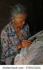 Yogyakarta, Java, Indonesia - July, 2020: Old Lady Painting Batik With Hand. Batik Is One Of Indonesian Heritages Which Has Become An Icon Of UMKM And National Dress In Indonesia. Javanese Batik.