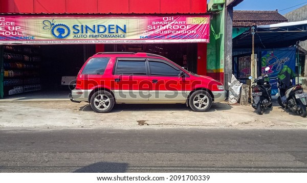 Yogyakarta July 17 2020 A red Mitsubishi Chariot\
Ressort Runner GT with Mitsubishi Lancer evolution engine parked on\
the front of a shop