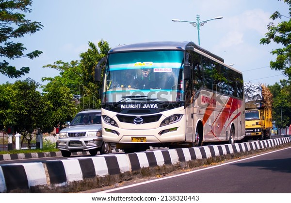 Yogyakarta, Sunday, July 21, 2013. The Murni Jaya bus\
bound for Merak-Jogja with the Hino symbol on the front grille\
crosses the southern ring road of Yogyakarta.  Seen a private car\
on the side and a