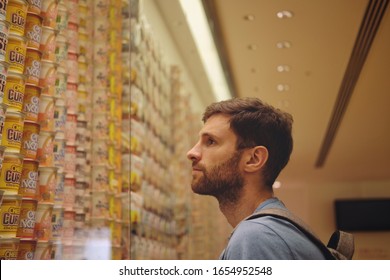 Yokohama, Japan - October 2019: A man is looking at the different flavors of instant noodles and ramen cups throughout history made by Momofoku Ando at the Ramen Cup Museum.