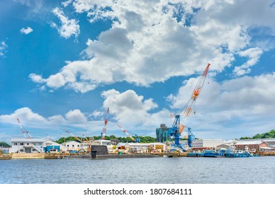 Yokosuka, Japan - July 19 2020: Sōryū Class Submarine 16SS Of The Japan Maritime Self-Defense Force Berthed In Front Of The Tower Cranes And Dry Docks Buildings Of The Yokosuka Naval Port.