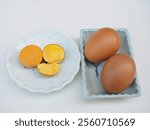 The yolk of a boiled chicken egg is placed on a plate on a white background. It has a deep yellow color and looks very delicious.