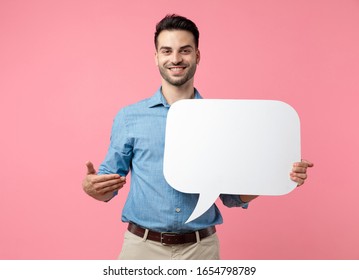 Yong Casual Guy Smiling And Presenting Speech Bubble, Standing On Pink Background