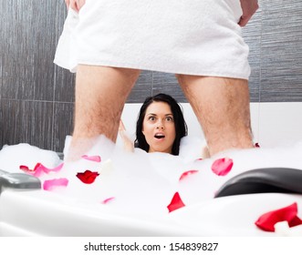 yong couple foreplay lying in jacuzzi, tub red rose petals, concept of intimacy lovers sexy man lover in towel underwear, surprised shocked woman lying looking scared to men's penis genital