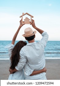 Yong Family With Wooden House Model And Enjoy On The Beach