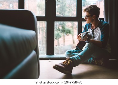 Yong Guy Plays On Guitar Sitting On The Floor In Living Room