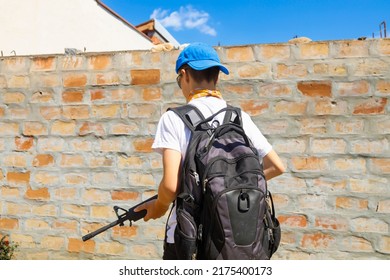 Yong man walking with an automatic rifle-Gun control, school shootings concept.