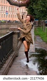 Yong Woman With Umbrella Jump Over The Puddle