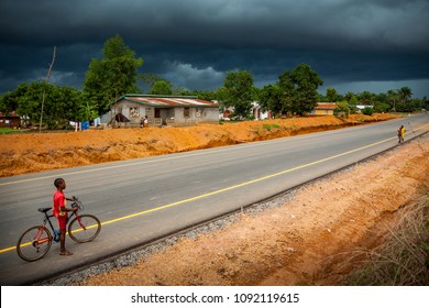 Yongoro, Sierra Leone - June 02, 2013: West Africa, Unknown Child With Bicycle Along The New Road That Leads To The Village In Front Of The Capital Of The Sierra Leone, Freetown