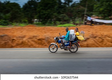 Yongoro, Sierra Leone - June 04, 2013: West Africa, Two Unknown People Travel The New Road That Leads To Yongoro On Their Motorcycles In Front Of The Capital Of The Sierra Leone, Freetown