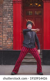 York, England - February 24 2018: A Contact Juggler Street Performer Using A Glass Ball In A Red Black Coordinated Outfit Performs In The City Centre Of Old Town York, England.