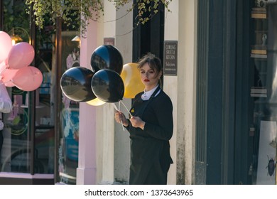 York, North Yorkshire, UK. 3.11.2019.Female Sales Assistant Stood Outside Of A Shop Holding Free Balloons For Passing Shoppers.