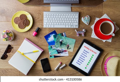 YORK, UK - APRIL 23, 2016. A Flat Lay Image Looking Down Onto A Busy Desk Full Of Items Needed To Book A Vacation On The Internet Including IPad With A 'to Do List', Vacation Photographs And Coffee.