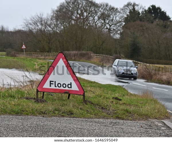 York UK Feb 16 2020\
car driving through floodwater on a flooded road in Rural York, the\
are has recently experienced above average rainfall, the road is\
still passable.