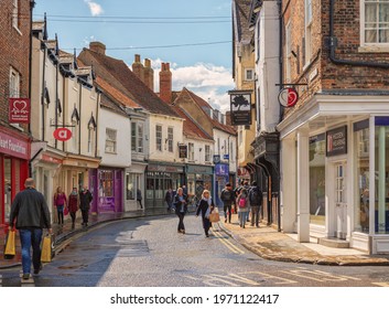 York, UK. May 7, 2021. Shopping Street Just After A Rain Shower. Historic Buildings Line The Street And Shoppers Walk Between Them. A Sky With Cloud Is Overhead.