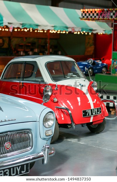 York, United Kingdom / 27th September 2015: BMW\
Isetta microcar was built in 1955 - small car in a showroom. Couple\
of travelers from Austria traveling by rare vehicle bicolor - red\
and creamy white