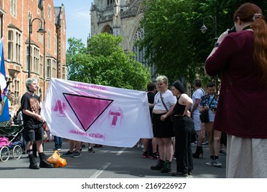 York, Yorkshire, UK. July 18, 2022. York Pride Parade. Banner with text liberation assimilation and inverted pink triangle forming word not