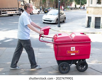 York, Yorkshire  UK - July 22nd 2021: Post Man Pushing Royal Mail Trolley Along Street York
