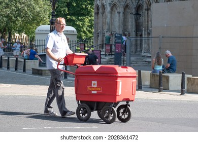 York, Yorkshire  UK - July 22nd 2021: Postman Pushing Royal Mail Trolley In Front Of Entrance To York Minster