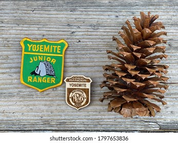 Yosemite, CA / USA - 06.23.2020: Yosemite National Park - Junior Park Ranger Badge And Sign.