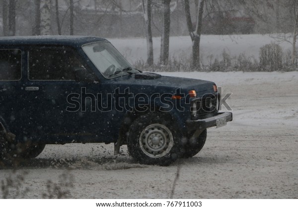YOSHKAR-OLA, RUSSIA - DECEMBER 03, 2017: Training\
in guided drifts on snow, ice and drifts into snowfall - drifting\
on an empty car park in the\
city\

