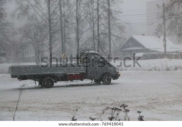 YOSHKAR-OLA, RUSSIA -\
DECEMBER 03, 2017: Training in guided drifts on snow, ice and\
snowdrifts into snowfall - drift on the cargo on-board machine- on\
an empty car park in the\
city