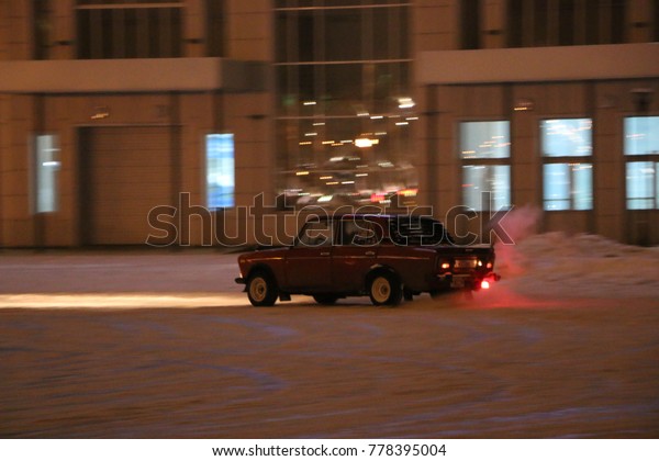 YOSHKAR-OLA, RUSSIA - DECEMBER\
08, 2017: Training in guided drifts on snow, ice and snowdrifts\
into snowfall,  drift on the rear-drive car-on an empty car park in\
the city