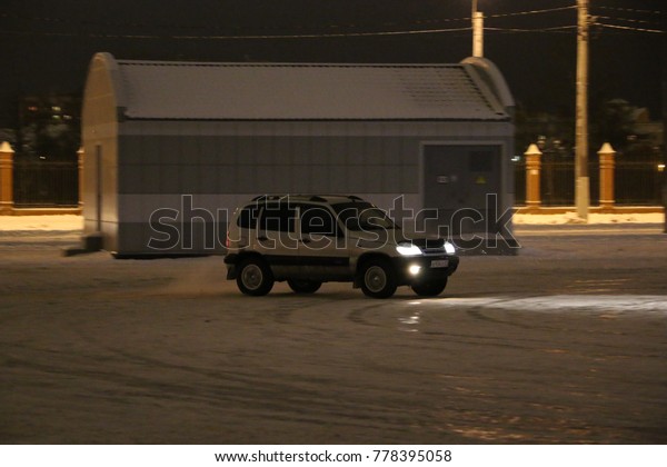 YOSHKAR-OLA, RUSSIA - DECEMBER\
08, 2017: Training in guided drifts on snow, ice and snowdrifts\
into snowfall,  drift on the rear-drive car-on an empty car park in\
the city